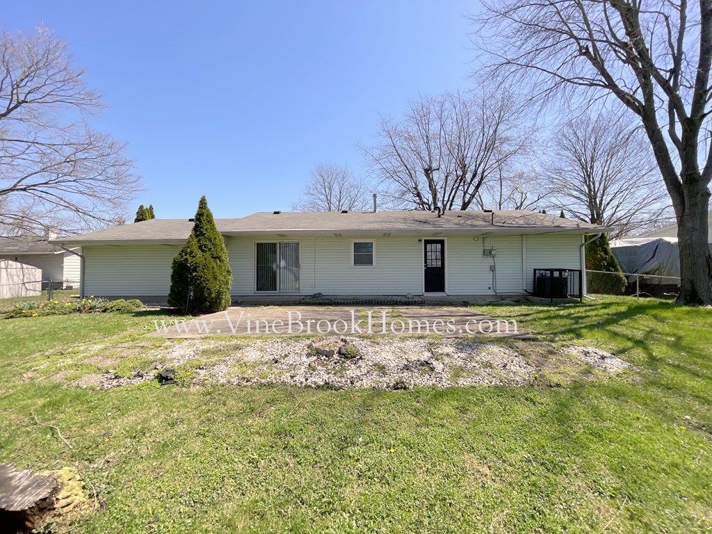 a small white house with a yard and a tree