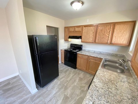 a kitchen with black appliances and wooden cabinets