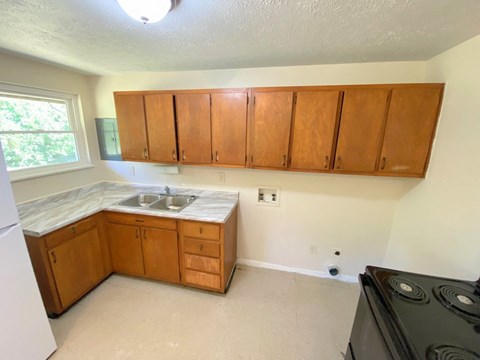a kitchen with wooden cabinets and a sink and a stove