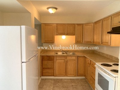 a kitchen with wooden cabinets and white appliances and a refrigerator