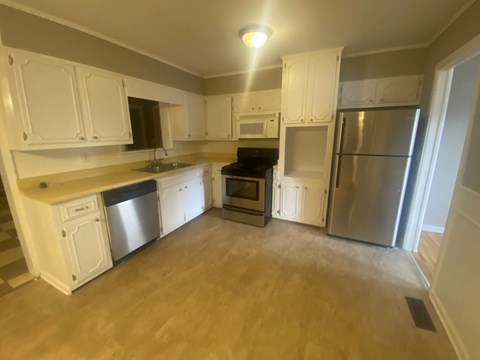 A kitchen with white cabinets and stainless steel appliances.
