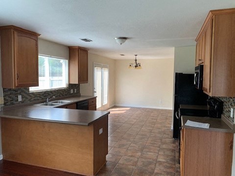 an empty kitchen with wooden cabinets and a sink