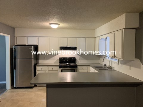 A kitchen with a stainless steel refrigerator and a countertop.