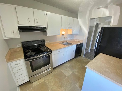 a kitchen with stainless steel appliances and white cabinets