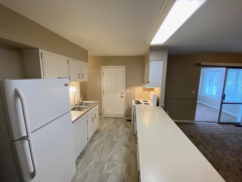 a kitchen with white cabinets and a white refrigerator
