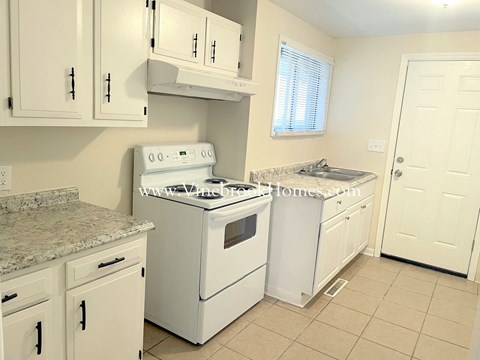 a kitchen with white appliances and counters and white cabinets