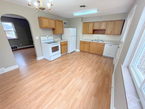 A kitchen with wooden floors and white appliances.