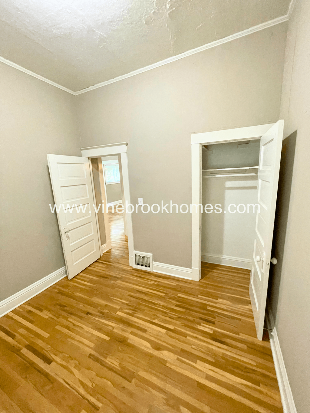 two closets in a small room with hardwood floors