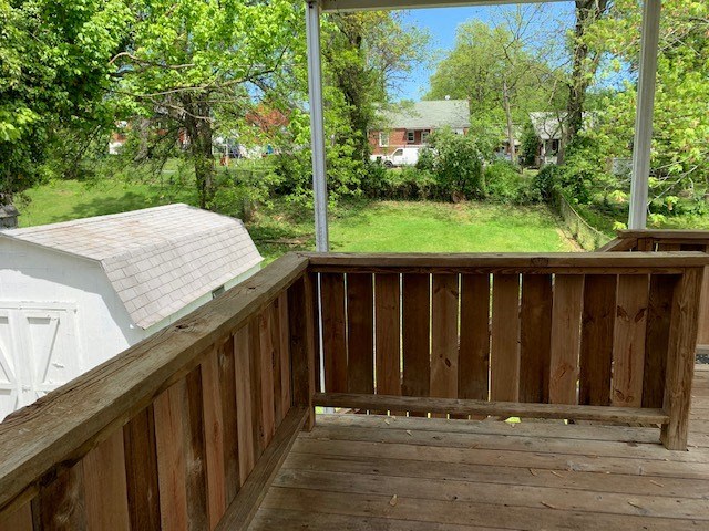a deck with a view of a yard and a house