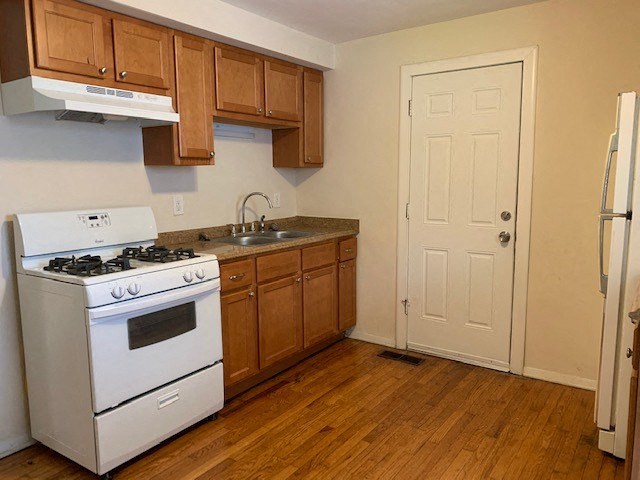 a kitchen with a stove and a sink and a refrigerator