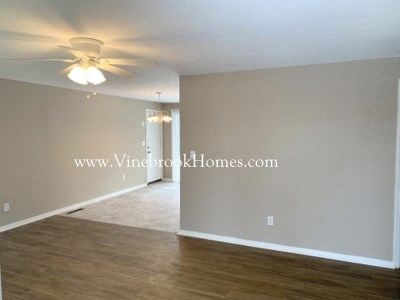 an empty living room with a ceiling fan