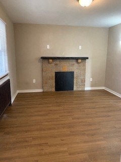 an empty living room with a fireplace and wooden floors