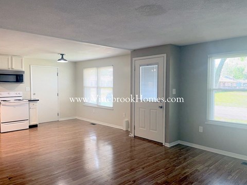 A kitchen with a white stove and a white refrigerator.