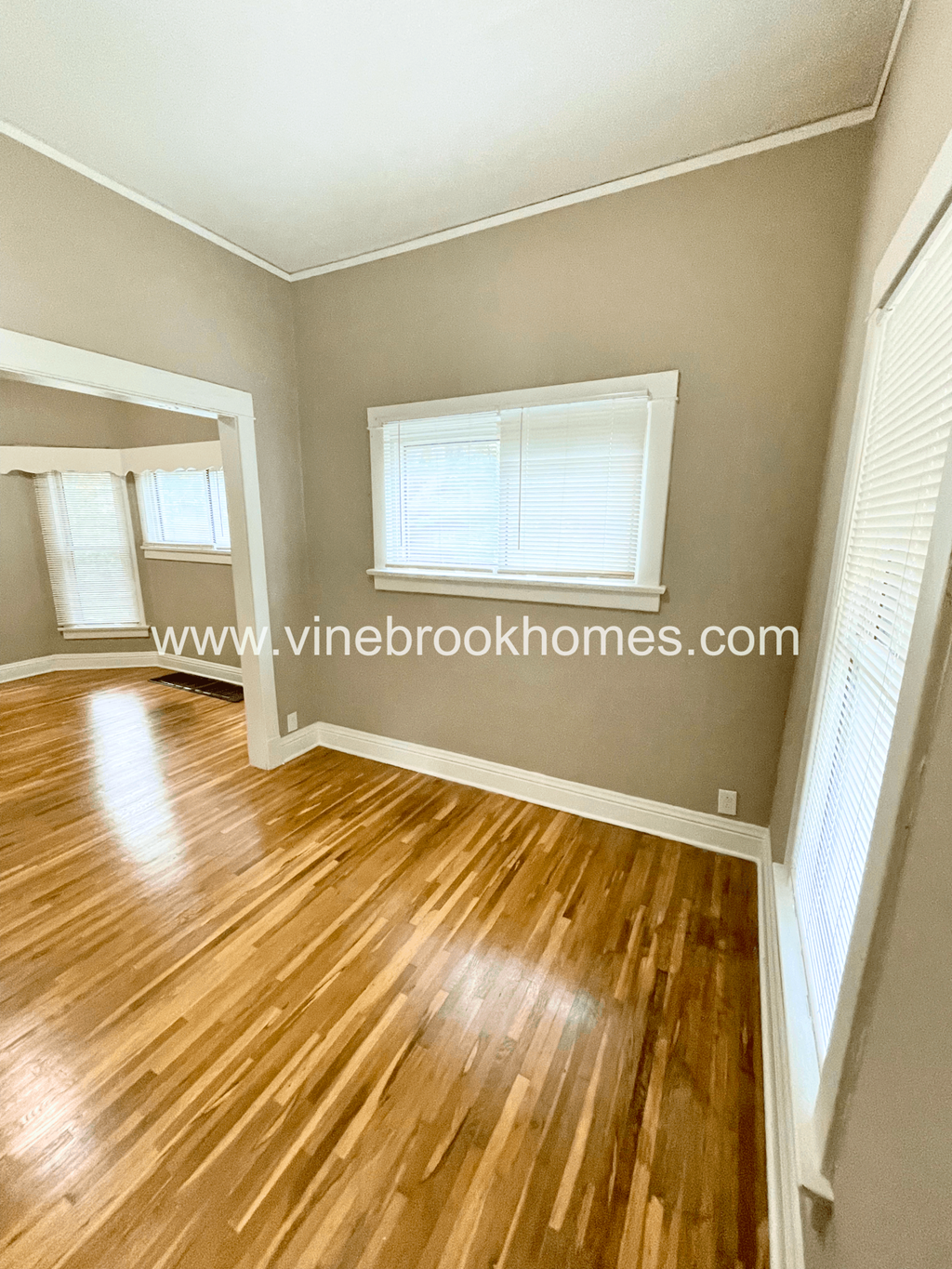 a small living room with a hard wood floor and a window