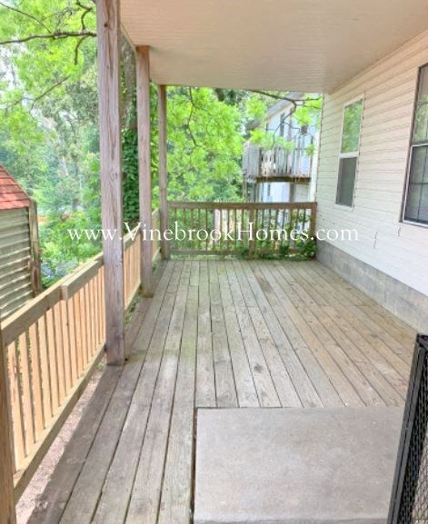 a porch of a house with trees in the background