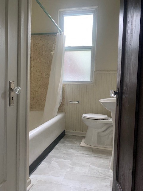 a bathroom with a toilet and a tub and a window