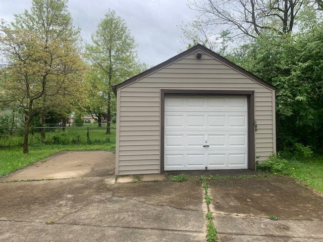 a small gray garage with a white garage door
