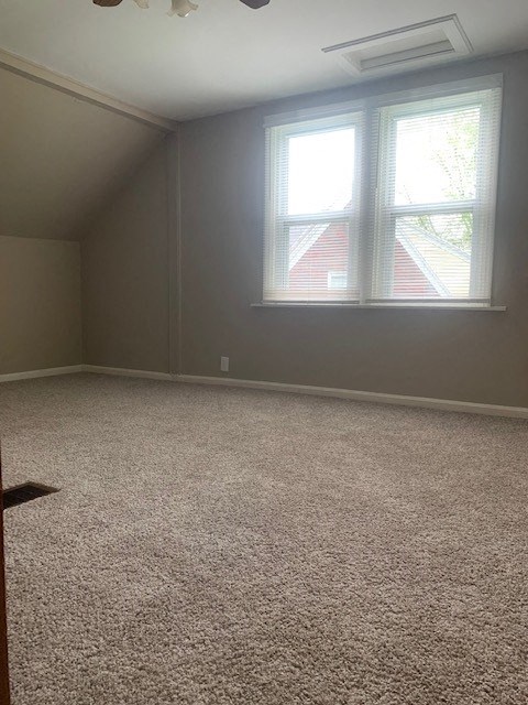 an empty room with two windows and a carpet floor