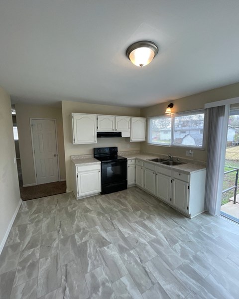 A kitchen with white cabinets and a black stove top oven.