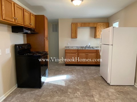 A kitchen with a black oven and white fridge.