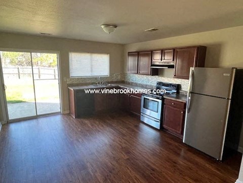 a kitchen with stainless steel appliances and wooden floors