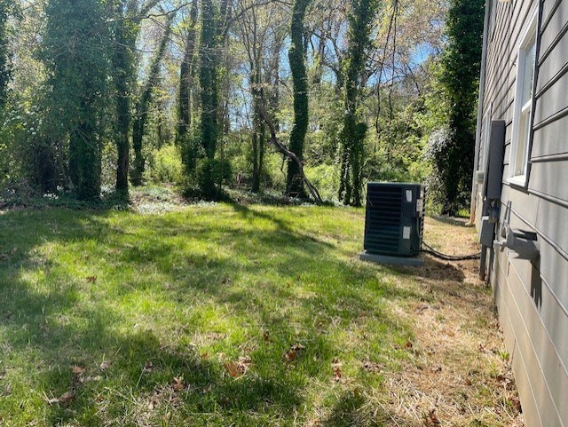 the side of a house with an air conditioner in the grass