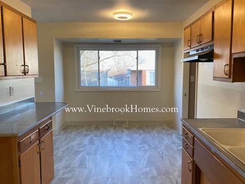 a kitchen with wooden cabinets and a window