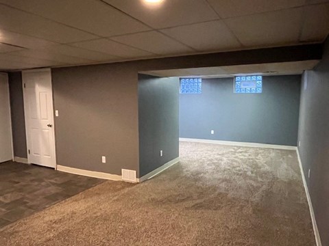 a living room with a blue wall and carpet and a door