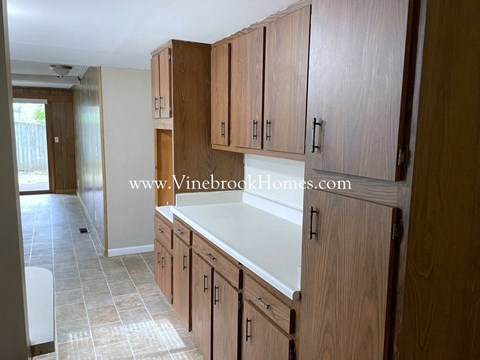 A kitchen with wooden cabinets and a white countertop.