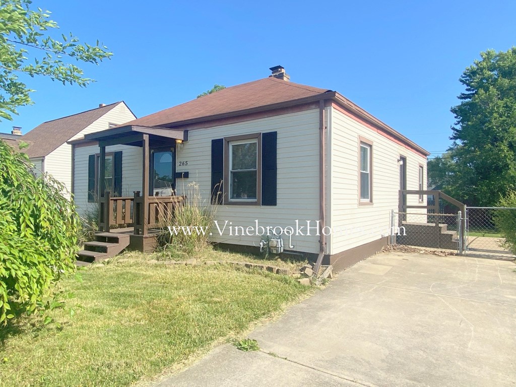 a small white house with a porch and a sidewalk