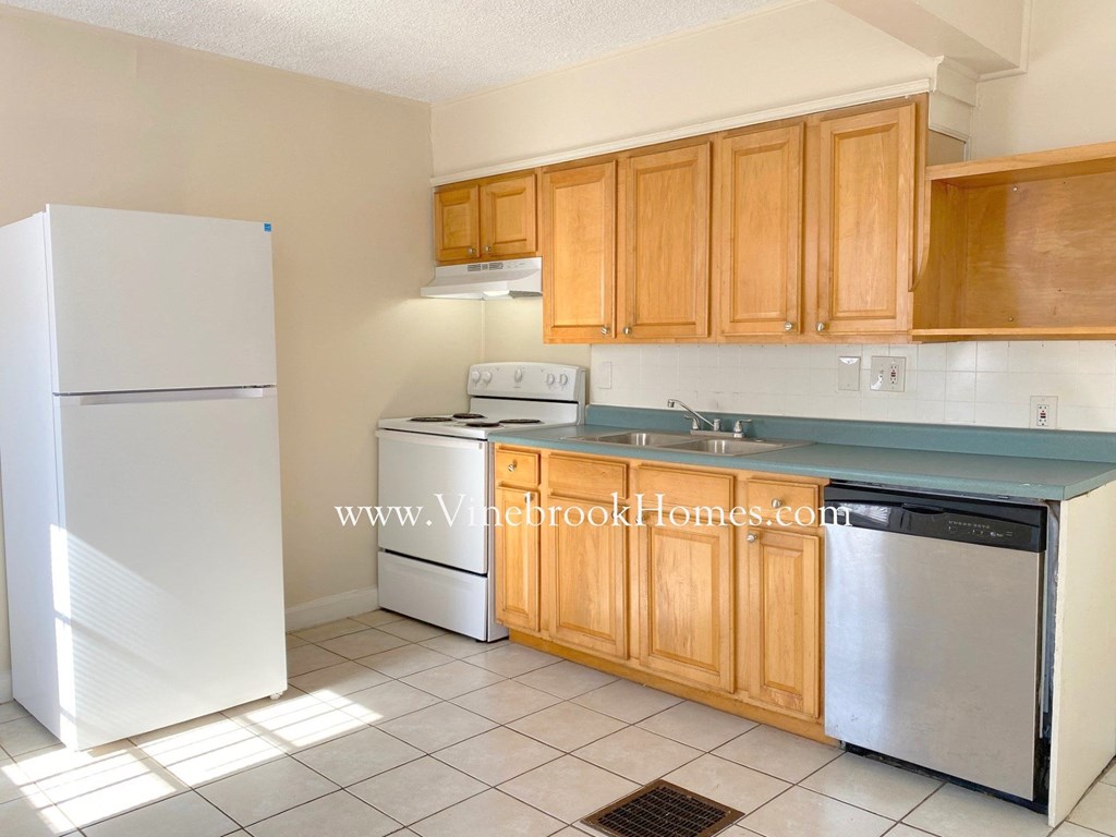 a kitchen with white appliances and wooden cabinets