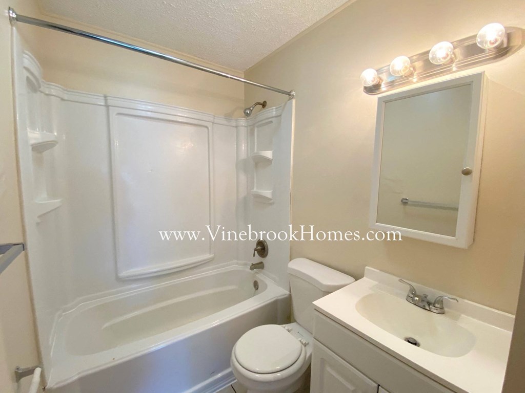 a white bathroom with a sink toilet and bath tub