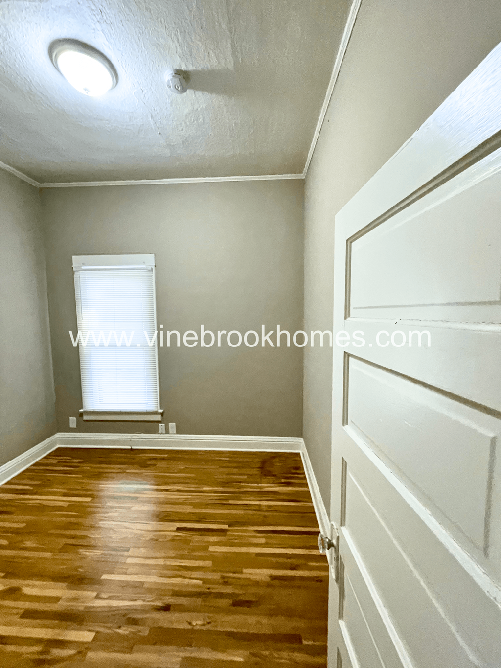 two bedroom apartment with hardwood flooring and a window