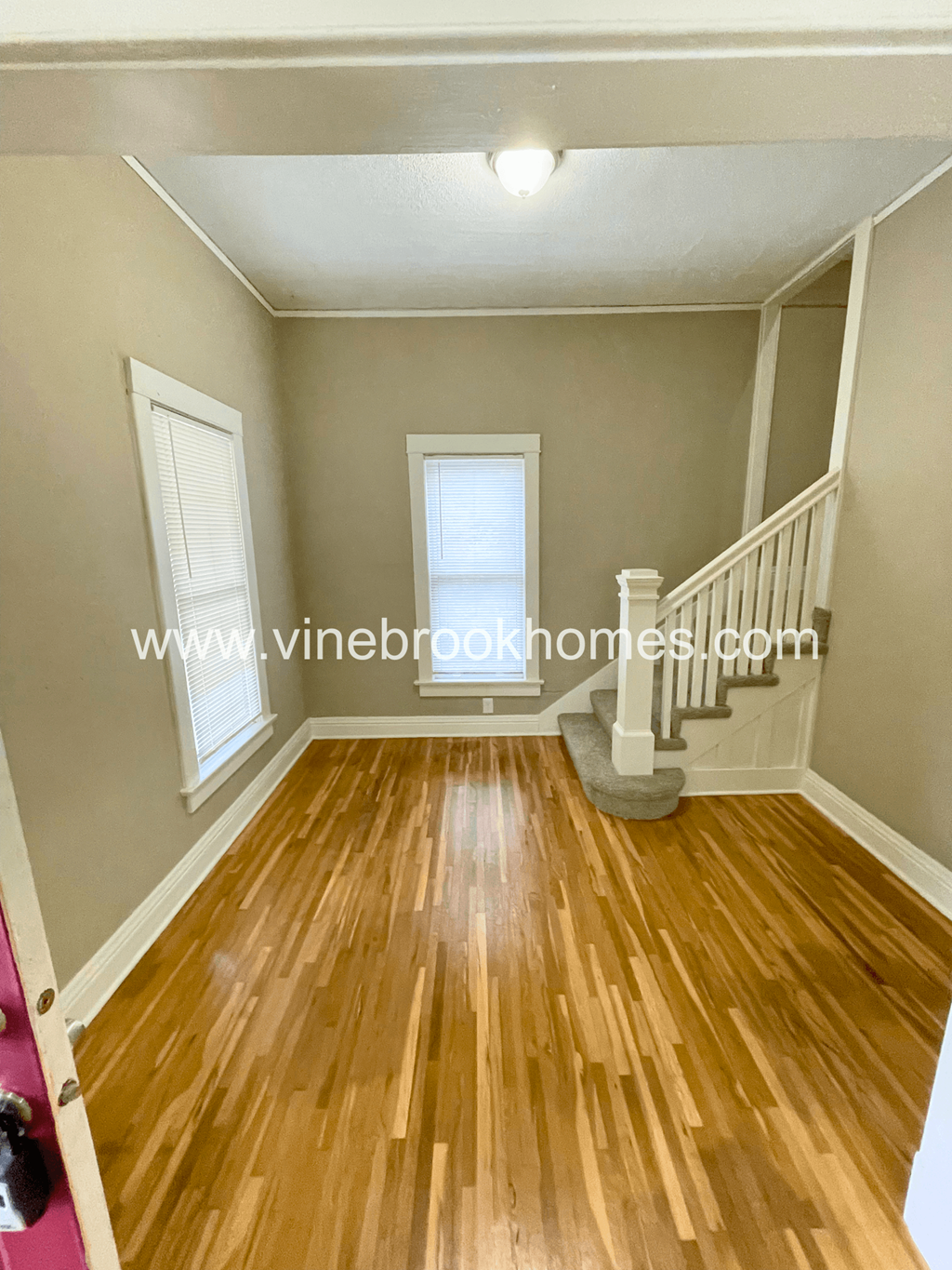 the second floor landing of this home has a hardwood floor and stairs