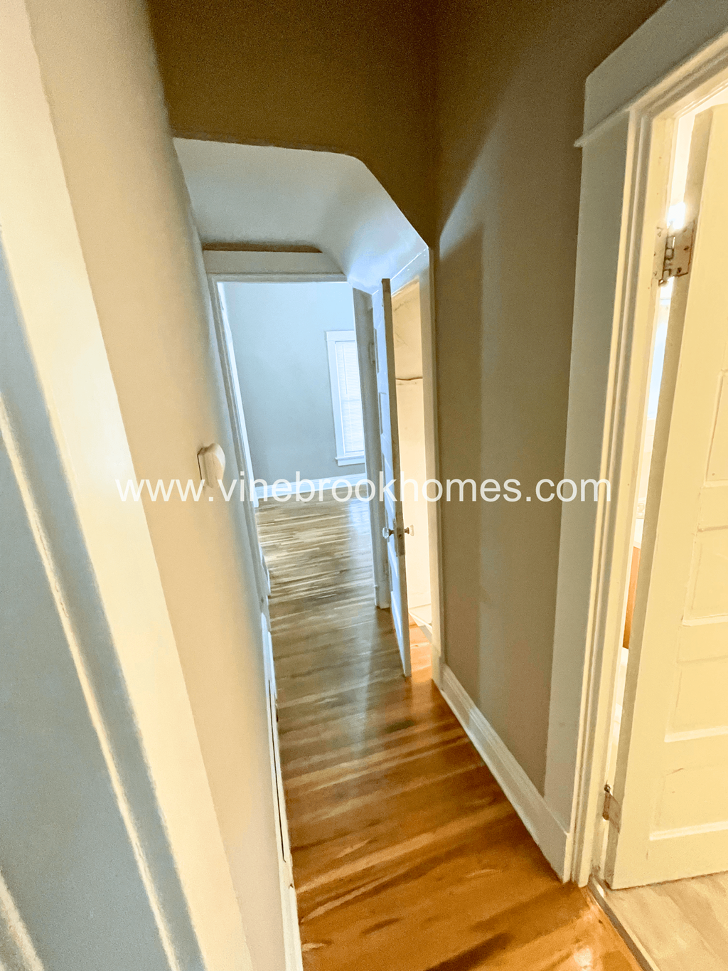 the hallway to the bedrooms is open and has a hard wood floor