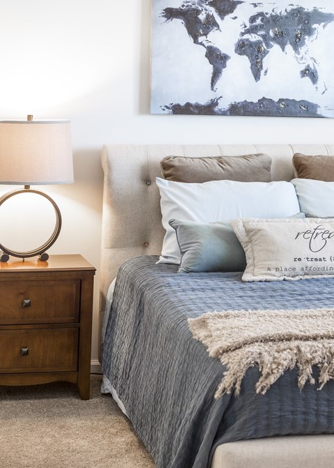 a bedroom with a bed and a nightstand with a lamp