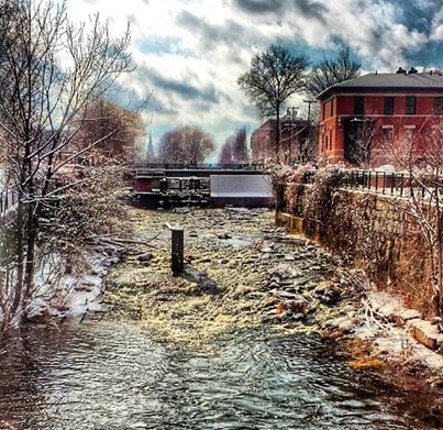 a river with a train on a bridge
