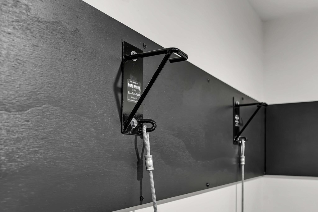 A black and white photo of a wall-mounted monitor with a cable attached to it.