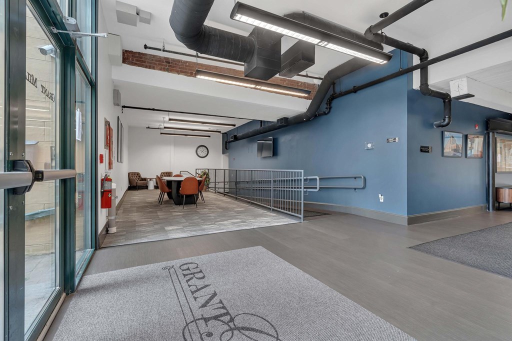 A room with a blue wall and a grey carpet with the word GRANTE on it.