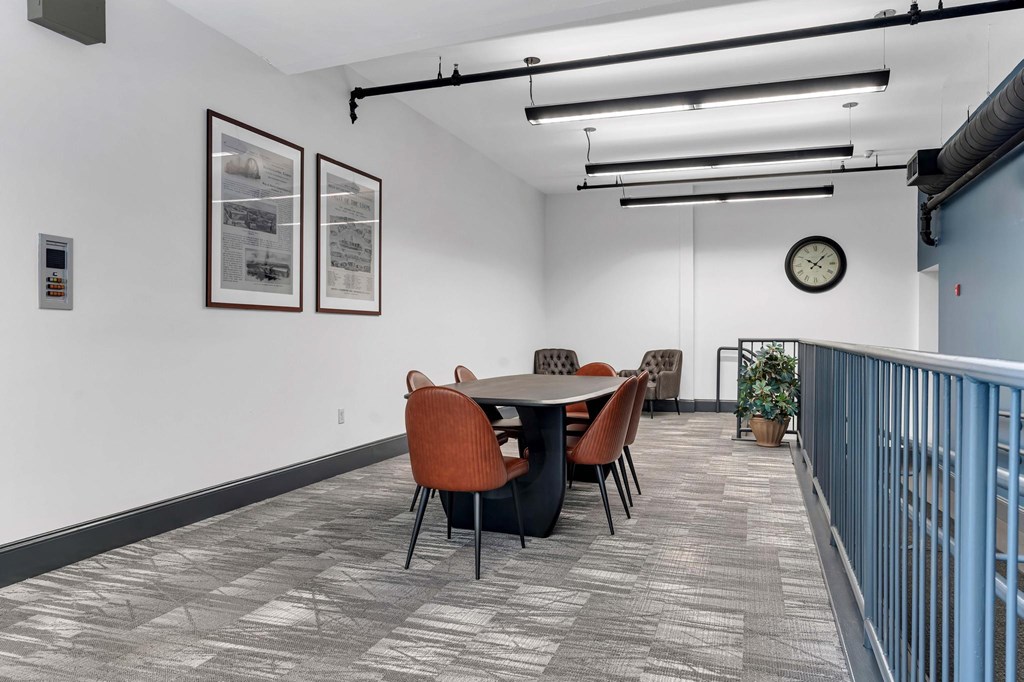 A conference room with a table, chairs, and pictures on the wall.