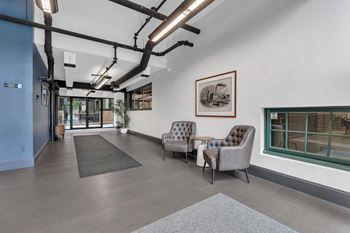 A room with a grey sofa and a brown armchair.