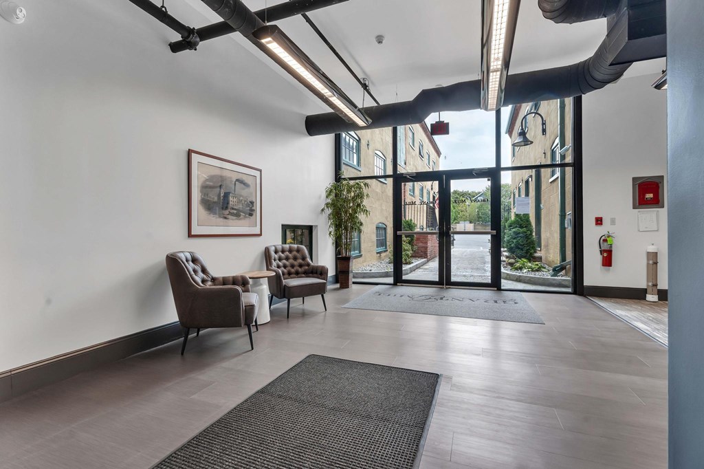 A room with a grey floor and a fire extinguisher on the wall.