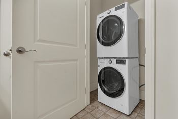 Two white front load washing machines in a laundry room.