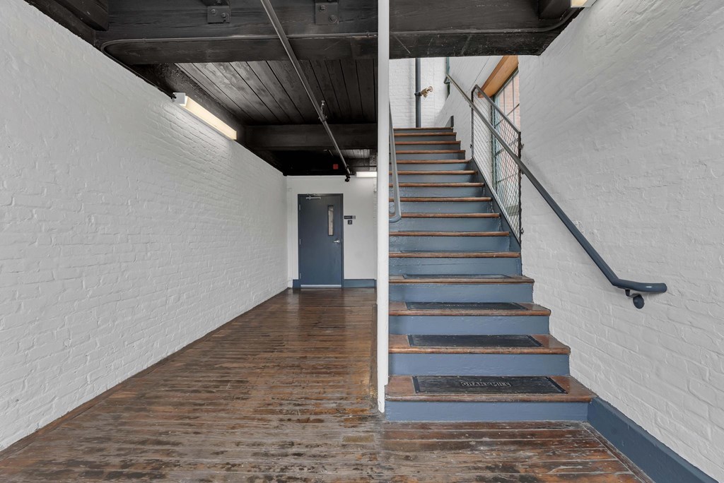 A staircase with a metal railing and wooden steps.