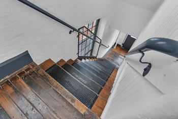 A staircase with a metal railing and wooden steps.