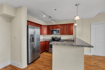 A kitchen with a refrigerator, microwave, oven, and sink.