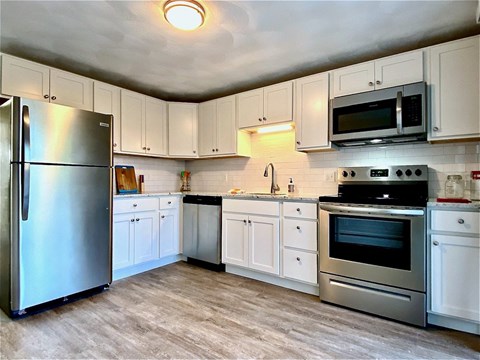 a kitchen with stainless steel appliances and white cabinets