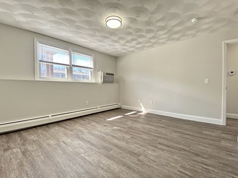 an empty living room with white walls and a window