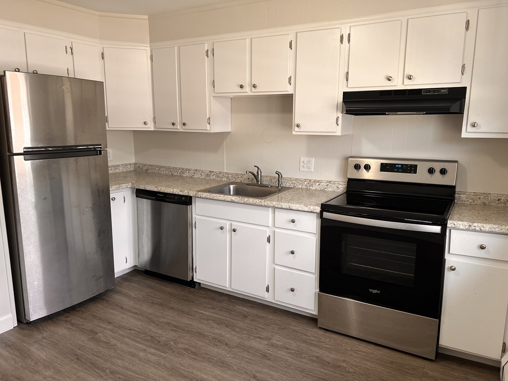 a kitchen with stainless steel appliances and white cabinets