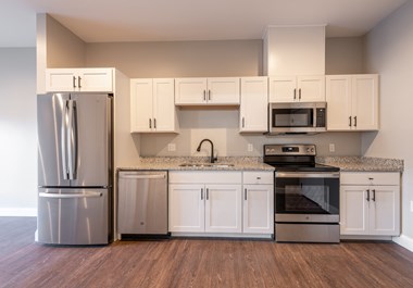 a kitchen with white cabinets and stainless steel appliances